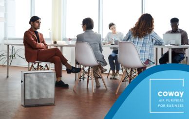 Office workers sitting at desks with Coway Airmega air purifier in the room